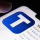 A finger hovers over the Truth Social Logo on an Apple iPhone